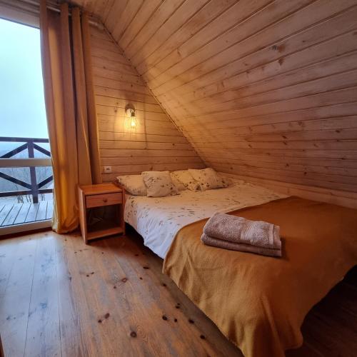 a bedroom with a bed in a wooden room at La Merveille 795-848-628 in Solina