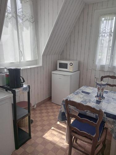une petite cuisine avec une table et un micro-ondes dans l'établissement Appartements Villa Odette, à Bagnoles-de-l'Orne