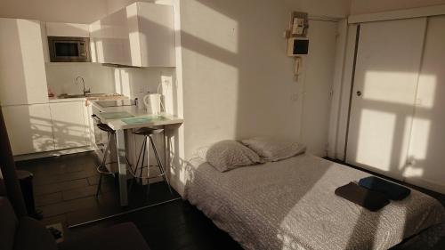 a small room with a bed and a small kitchen at Studio Hypercentre proche gares et métro in Lille