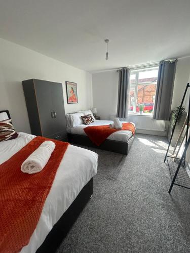 a hotel room with two beds and a window at Stylish New 4BR - Great for Groups - Free Parking in Leicester