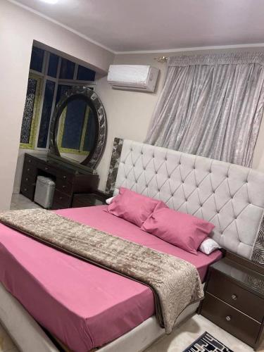 a bedroom with a large bed with pink sheets at الاغوار bb in Khirbat ash Shaykh Muḩammad