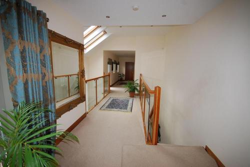 a hallway with a stairway with a plant at Serene Luxurious Haven with Sea Views Letterkenny Rooms in Letterkenny