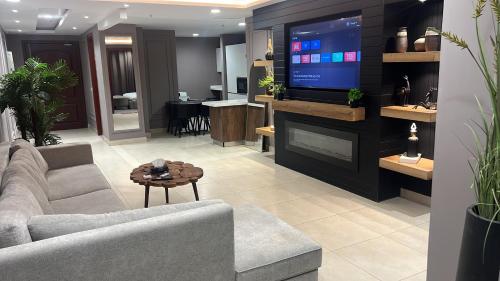a living room with a couch and a tv at Gold Crest Apartments Luxurious in Lahore