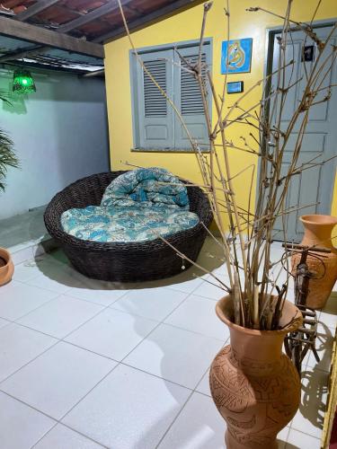 a room with a bed and a vase with a plant at Bru&Mar Pousada in Parnaíba