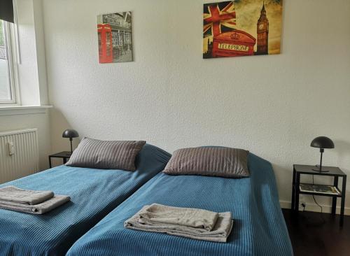 two beds in a bedroom with towels on them at H&M Homes Apartments in Aarhus