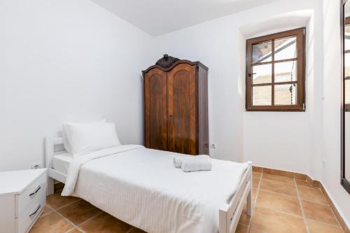 a white bedroom with two beds and a window at Casa del Sol in Strp