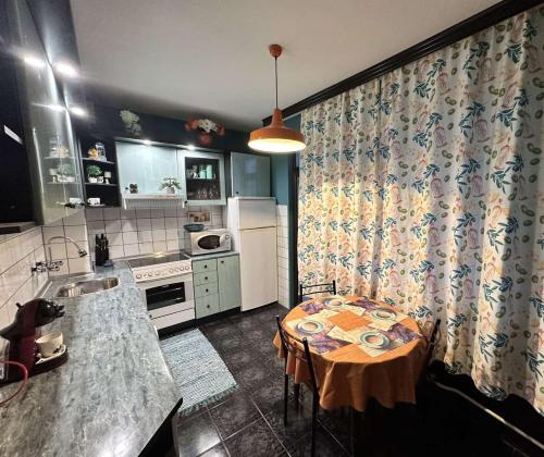 a kitchen with a table and a kitchen with a table and a tableablish at Апартамент за гости НИКИА в центъра с изглед към Врачанския Балкан Nikia Cityscape & Mountain Escape in Vratsa
