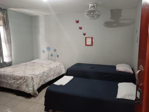 a room with two beds in a room at Lirio Green hostal in Managua