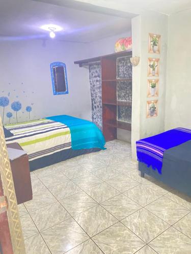 a bedroom with two beds and a table in a room at Lirio Green hostal in Managua