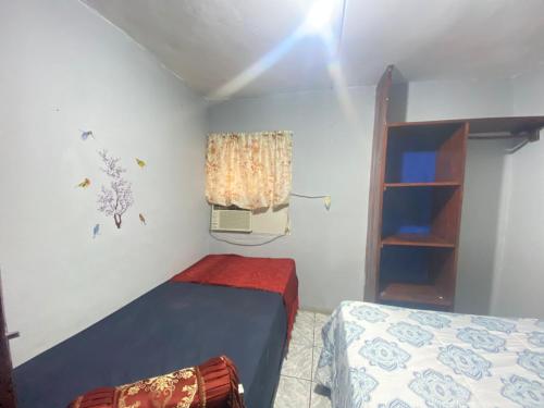 a small bedroom with a bed and a window at Lirio Green hostal in Managua