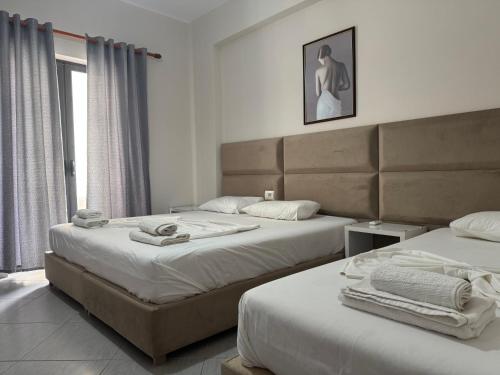 a bedroom with two beds and a window at Gersa's Family Studios in Sarandë