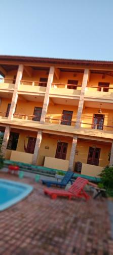 an apartment building with a swimming pool and lawn chairs at Village Lagoinha Ceará in Tigre