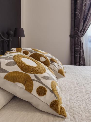 a bed with brown and white pillows on it at Cavour 21 Apartment in Certaldo