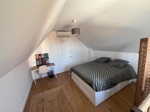- une chambre mansardée avec un lit noir et blanc dans l'établissement Charmant duplex rénové à proximité de Troyes, à Sainte-Savine