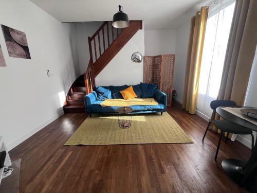 - un salon avec un canapé bleu et un escalier dans l'établissement Charmant duplex rénové à proximité de Troyes, à Sainte-Savine