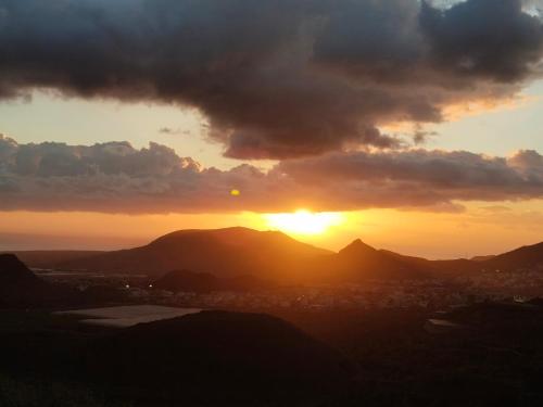 a sunset with the sun setting behind the mountains at Los Eucaliptos in Fasnia