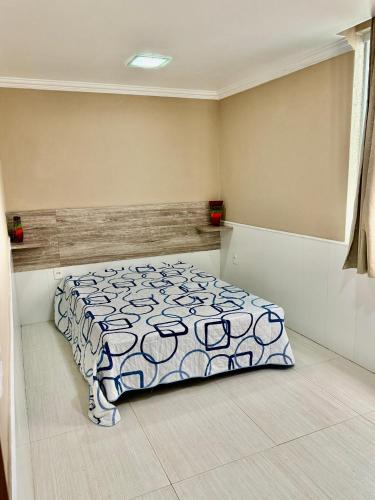 a bedroom with a bed with a blue and white comforter at Casa lazer Atafona in São João da Barra