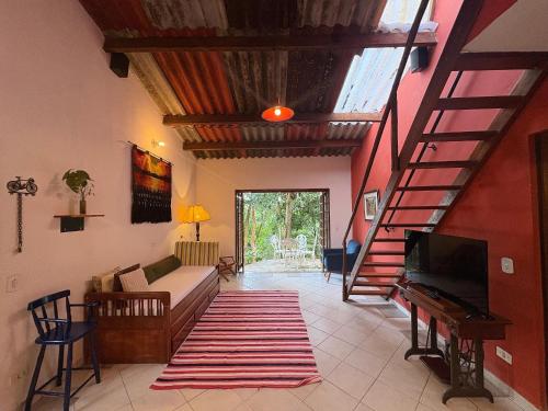 a living room with a staircase and a couch and a television at Casa Amarela, Refúgio na natureza Rota do vinho in São Roque