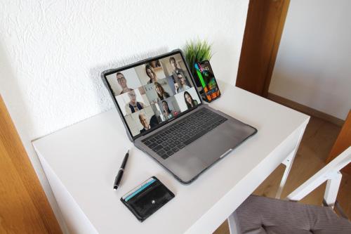 a laptop computer sitting on a white table at Downtown Apartments Ulm - im Herzen von Ulm & komfortable Boxspringbetten in Ulm