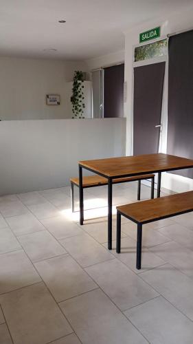two wooden tables and benches in a room at Pisadas II Rivadavia 532 in Río Colorado