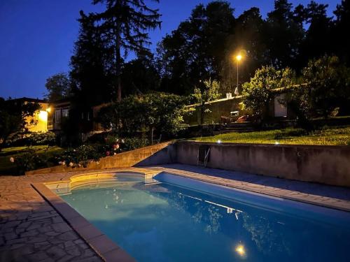 une piscine dans un jardin la nuit dans l'établissement La maison perchée, au Puy-en-Velay