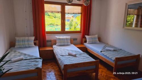 drei Betten in einem Zimmer mit Fenster in der Unterkunft Uma in Bihać