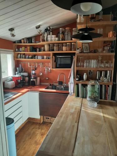 - une cuisine avec des murs orange et une table en bois dans l'établissement Appartement avec terrasse centre, à Bordeaux