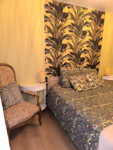 une chambre avec un lit et une chaise dans l'établissement gîte au coeur d'argent, à Sainte-Croix-aux-Mines