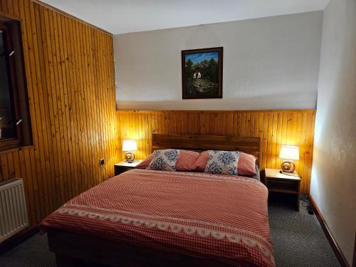 a bedroom with a bed with two lamps on both sides at Vila Kamila in Tatranska Strba