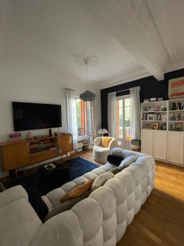 un salon avec un canapé blanc et une télévision dans l'établissement Palais Libération 3 pièces, à Nice