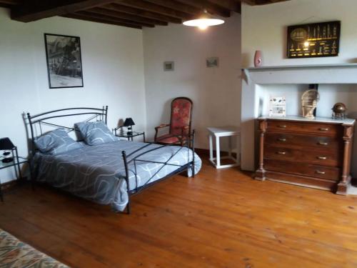a bedroom with a bed and a dresser at Maison ARDELLI in LʼHôpital-dʼOrion