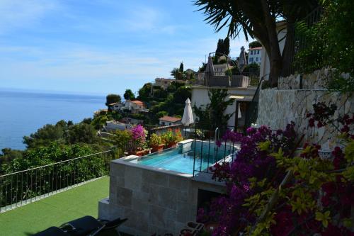une maison avec une piscine sur une colline à côté de l'océan dans l'établissement Petit coin de Paradis a cote de Monaco, à Roquebrune-Cap-Martin