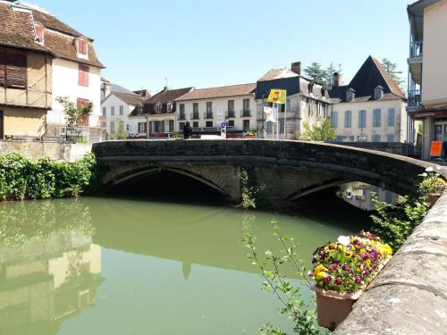 a bridge over a river in a city at Maison ARDELLI in LʼHôpital-dʼOrion