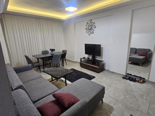 a living room with a couch and a table at Turkuaz sitesi 2 odalı eşyalı ve havuzlu manzaralı kişi fiyatı değil oda fiyatı in Side