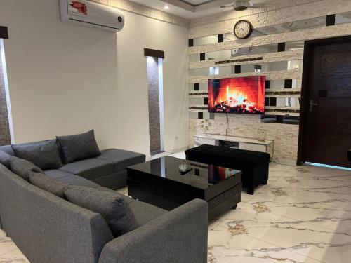 a living room with a couch and a tv at Luxor Apartments & Suites - DHA Phase 9 in Lahore