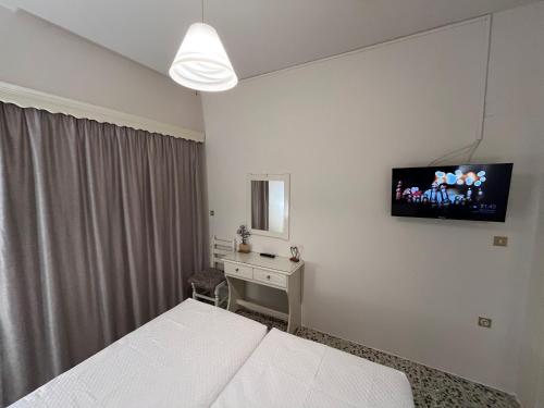 a bedroom with a bed and a television on the wall at Nikos Studios in Keri