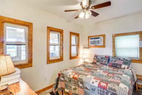 une chambre avec un lit et un ventilateur de plafond dans l'établissement Lakefront Ozark Cottage Deck with Covered Dock!, à Edwards