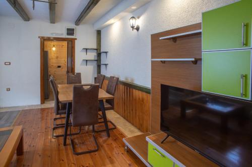 Un comedor con una mesa y un televisor de pantalla plana. en Quiet City Apartments, en Žabljak