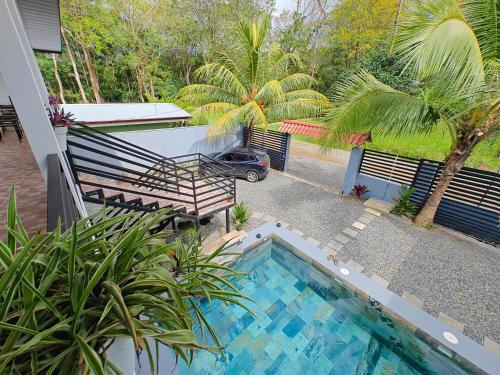 a swimming pool with a bench and a car in a yard at AJ House & Suites in Uvita