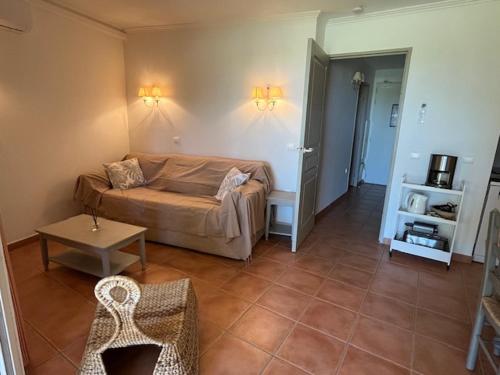 un salon avec un canapé et une table dans l'établissement Appartement de charme sur le domaine de Pont Royal à Mallemort, en rez-de-jardin avec terrasse & piscine et vue sur le Golf, à Mallemort