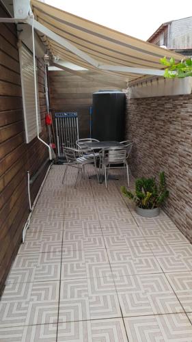 a patio with a table and chairs on it at cAMÉLIAS in Petit-Bourg