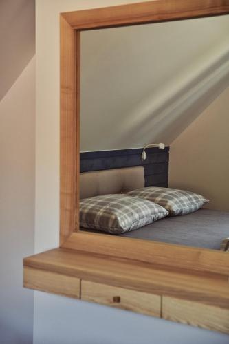 a mirror on top of a bed in a room at Domki na Kaszubach - nad jeziorem z balią i sauną in Bytów