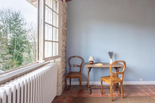 a room with a table and two chairs and a window at charming nature lodge in Périgord in Négrondes