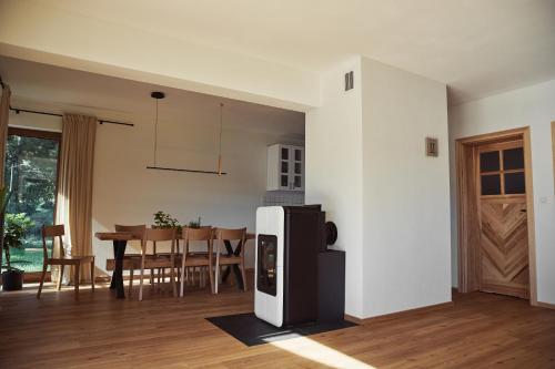 a kitchen and dining room with a refrigerator and a table at Domki na Kaszubach - nad jeziorem z balią i sauną in Bytów