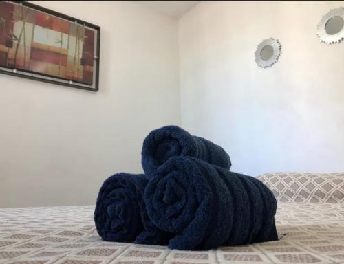 a pile of towels sitting on a bed at CASA DORADO B con AC y SMART TV Planta Baja in Mezcales