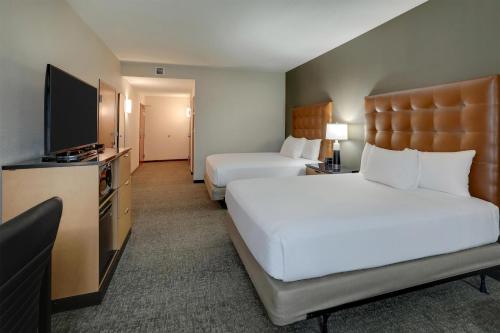 a hotel room with two beds and a flat screen tv at Drury Inn & Suites Montgomery in Montgomery