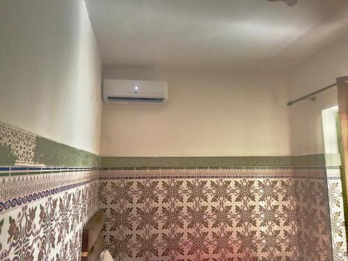 a bathroom with green and white tile on the wall at Riad Dar Lokman in Marrakech