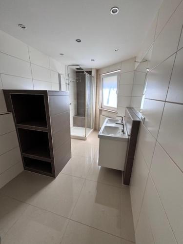 a large white bathroom with a sink and a window at Citynah und Modern - Helle Wohnung mit Komfort in Nürnberg