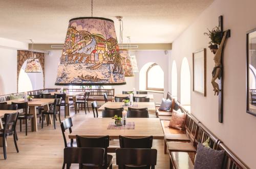 a restaurant with tables and chairs and a large chandelier at POST AM SEE in Traunkirchen