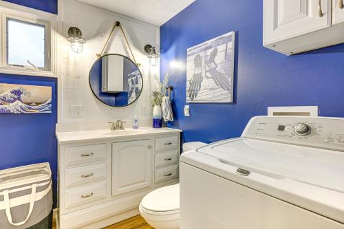 baño con aseo blanco y pared azul en 2 Fire Pits and Lake Access Cozy Mecosta Getaway!, en Mecosta